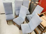 plusieurs chaises et une table dans une pièce avec un mur rouge en arrière-plan