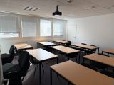 des tables et des chaises dans une pièce équipée d'un ventilateur de plafond et de fenêtres