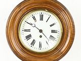 a clock hanging on the wall with roman numerals on it