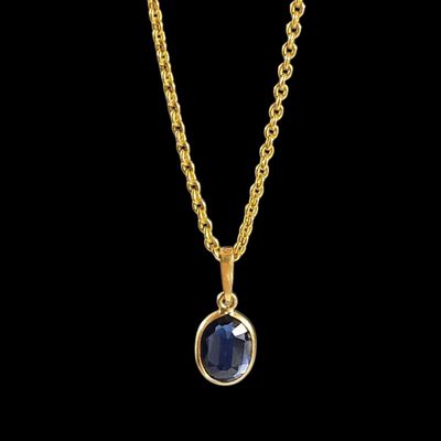 un collier en or avec une pierre bleue sur une chaîne