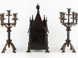 three metal candelabs with candles and a mirror in front of them