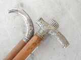 a silver and wood walking stick and a silver and wood walking stick
