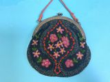 black beaded purse with pink flowers and leaves hanging from a string