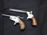 two old revolvers sitting on top of a black cloth