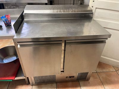 un plan de travail en acier inoxydable sur lequel sont posées une casserole et une poêle