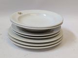 several white plates stacked on top of each other on a table