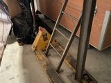 un homme debout à côté d'une échelle dans un garage