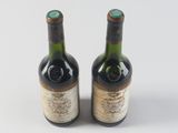 two bottles of wine sitting next to each other on a white surface