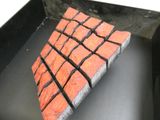 un morceau de brique rouge posé sur un plateau noir