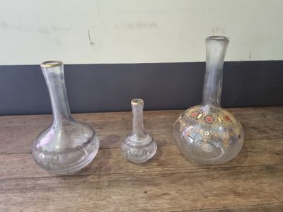 three glass vases sitting on a table next to each other