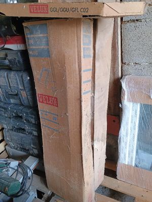 une pile de cartons posée sur une palette près d'une fenêtre