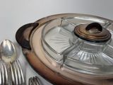 a silver plate with a glass lid and silver spoons