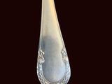 a silver spoon with a silver handle on a black background