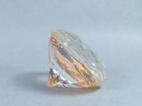 a clear and yellow diamond on a white surface