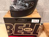 bell motorcycle helmet and helmet bag sitting on a table next to a brick wall