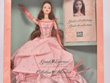 La poupée Barbie se trouve dans une boîte rose sur laquelle figure une image.