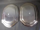 pair of silverplated oval serving trays on a table