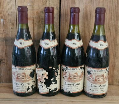 four bottles of wine are lined up on a wooden shelf