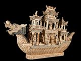 a statue of a boat with a dragon on the front of it