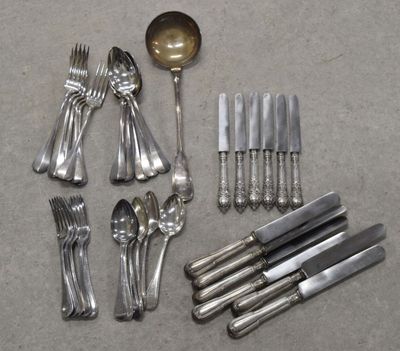 de nombreuses cuillères et fourchettes en argent éparpillées sur le sol