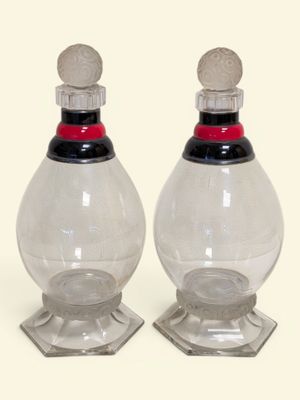 paire de salières et poivrières en verre transparent avec des couvercles rouges