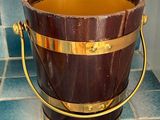 a wooden bucket sitting on a tiled floor in a bathroom