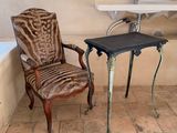 a chair that is next to a table with a laptop on it