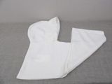 a white towel on a bed next to a pair of pants