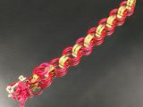 bracelet à maillons roses et dorés orné d'une breloque en forme de croix