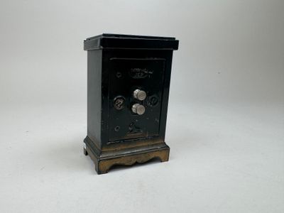 a small black clock on a stand on a white surface