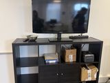 a black entertainment center with a flat screen tv on top of it