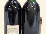two bottles of wine sitting next to each other on a table