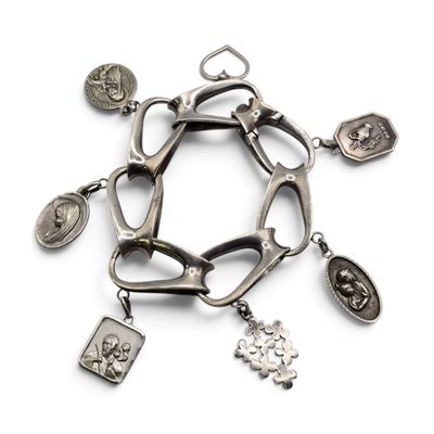 bracelet en argent orné de breloques religieuses et d'autres breloques sur fond blanc