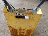 a yellow box with a black handle sitting on the ground