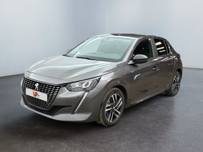 La voiture grise est garée dans une grande pièce au sol noir.