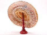 un support rouge sur lequel est posé un ventilateur, sur fond blanc