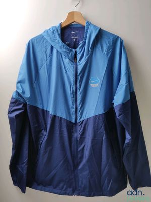 une veste bleue et noire accrochée au mur, à côté d'un cintre