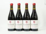 quatre bouteilles de vin rouge posées sur une table blanche