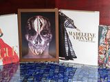 quatre livres posés sur une table sur laquelle se trouve la photo d'une femme