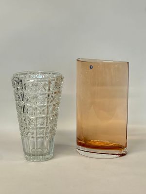 two glass vases sitting next to each other on a table