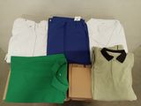 several men ' s shirts and pants are laid out on a table