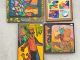 Plusieurs tableaux sont accrochés au mur d'une pièce.