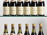 Plusieurs bouteilles de vin sont alignées sur une étagère en verre