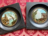 deux tableaux encadrés représentant un paysage et un château sur un fond rouge et or