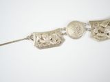 two silver bracelets on a white surface with a chain