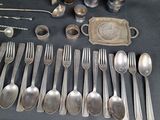 a lot of silver spoons and forks and spoons on the table