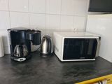 a microwave, coffee maker, and other appliances on the counter