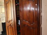 une photo d'une grande armoire en bois dans un salon