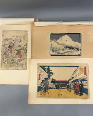 deux anciennes estampes japonaises représentant des personnages et des bâtiments, exposées dans un musée