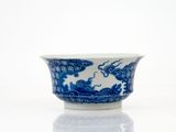 un bol bleu et blanc posé sur une surface blanche